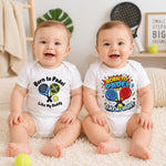 Two smiling babies wearing white “Born to padel like my Daddy” bodysuits in different racket-themed designs.