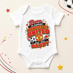 White Manchester United baby bodysuit with “Born to support just like Daddy”, club crest and football graphic.