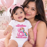 Woman holding a smiling baby wearing a personalised 8 months old unicorn bodysuit and pink bow headband.