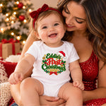 A baby wearing a white short-sleeve bodysuit with a colorful 'Eddie's First Christmas 2024' graphic sits on a woman's lap. The baby also wears a red bow headband.