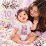 Woman with a smiling baby wearing a personalised 10 months old fairy princess bodysuit beside a cake and flowers.