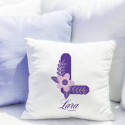 White pillow with purple letter 'L' and floral design, featuring the name 'Lara', on a white couch.