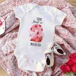 Baby onesie with milestone design on a pink blanket