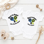 White personalised padel bodysuit and T-shirt with crossed rackets and custom auntie and uncle messages.