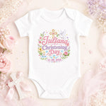 White personalised christening day baby bodysuit with pink lettering, name and date, cross and floral decorations.