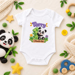 White personalised 1 month old panda baby bodysuit with a green number and purple name, beside a panda toy.