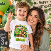 Woman with a smiling child wearing a personalised Bishop “3 Rex birthday” T-shirt at a dinosaur-themed celebration.