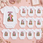 Personalised pink safari milestone bodysuit set for months 1–12 with animal illustrations, green leaves and flowers.