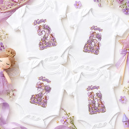 Four white personalised fairy princess milestone bodysuits with ornate purple floral numbers, crowns and pastel props.