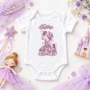 White personalised 1 month old fairy princess baby bodysuit with purple flowers, a castle toy and fairy doll.