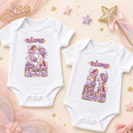 Two white personalised fairy princess milestone bodysuits with purple floral numbers 9 and 10 on peach.
